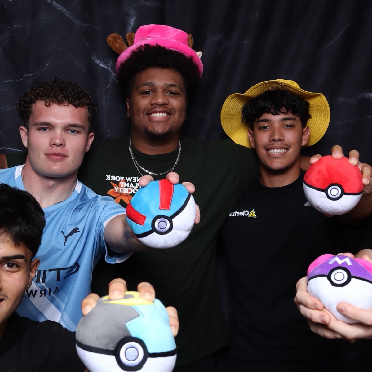 a group of four crowded into the booth with props